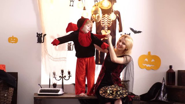 Mom and son play for halloween witches costume at home. Mother and child boy playing together. 31 october. Magic hat. Best ideas for Halloween. Mother wearing as witch, son wearing as devil.