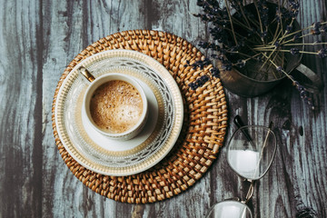 Tasse de café en porcelaine blanche et dorée sur une table en bois vintage