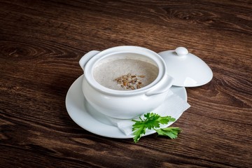 Vegetarian mushroom champignon cream soup on a dark table