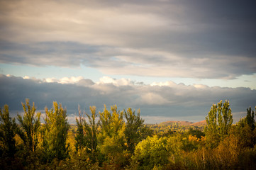 Autumn urban landscape on a Sunny day - yellow and colorful autumn trees, the sky with clouds with autumn haze