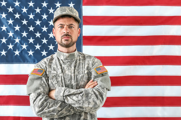 Soldier in camouflage with national flag of USA on background