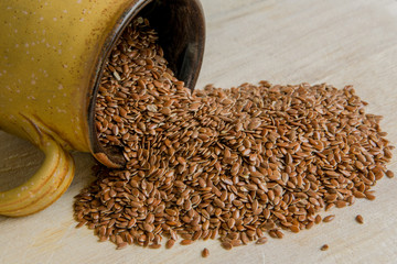 Obraz premium Flax seeds in a cup on wooden background