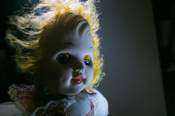 scary old doll under dramatic light
