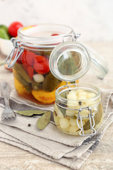 Jars with different canned vegetables on table