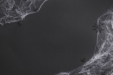 Traditional halloween background with spiders. Place for text. Black spiders, white web on black background. Top view. Flat lay