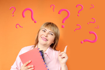 European woman with notebooks in hand smiles and shows fingers on the background of a lot of white...