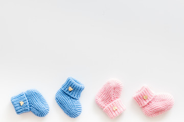 Cute baby booties for girl and boy on white background top view copyspace