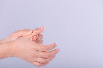 Woman suffering from hand pain on grey background.