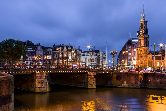 Doelensluis bridge over Rokin river with the Mint Tower (aka Munttoren) landmark in the background in Amsterdam, The Netherlands.