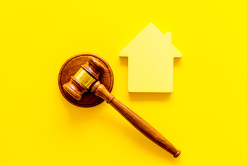 Inscribed gavel, house figure for inheritance concept on yellow background top view