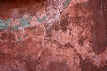 Red plaster wall with pealing paint