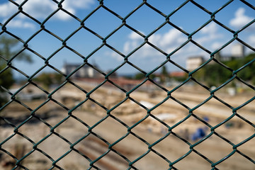 Fototapeta premium Green wired fence with blurry background