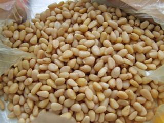Pine nuts close-up. White peeled pine nuts in a package. Useful products for vegetarians.