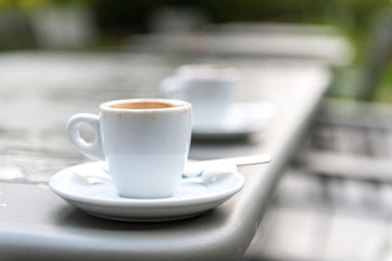 Two empty cups of coffee, the one in front is sharp / focused