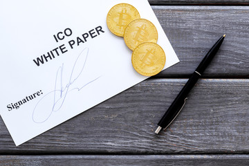 White paper ICO, coins, pen on wooden background top view