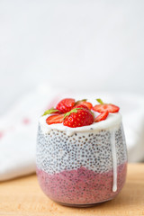 Chia pudding with almond milk, yogurt, pitaya powder and strawberries.