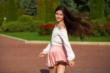 Pretty stylish brunette girl in plaid skirt and white blouse