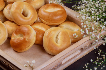 Close up of fresh mini bagels on wooden tray.