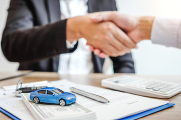 Sale agent handshake deal to agreement successful car loan contract with customer and sign...