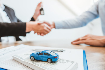 Sale agent handshake deal to agreement successful car loan contract with customer and sign...