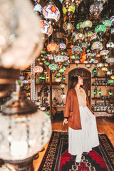 Happy travel woman choosing Amazing traditional handmade turkish lamps in Local souvenir shop ,Goreme. Cappadocia Turkey