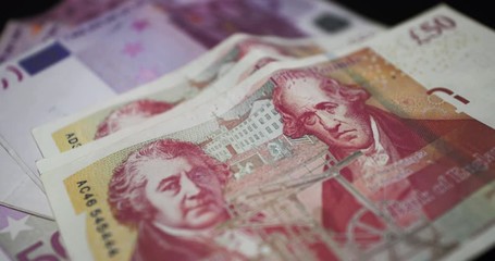 Slow Motion Rack Focus Shot Of Five Hundred Euro Notes And Fifty Great Britain Pounds Notes - €500 Euros And £50 GBP Bills - 4K 30fps - Powered by Adobe