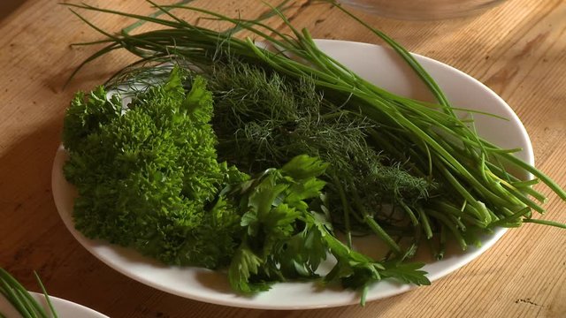 Steady, medium close up shot of fresh dill, rosemary, parsley and chives.
