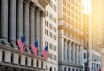  Amerikaanse vlaggen wapperen voor de historische gebouwen van Wall Street in het financiële district van Manhattan, New York City © deberarr