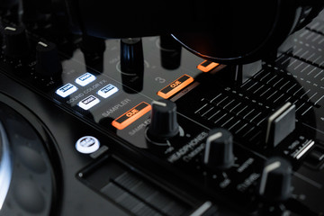 Professional dj headphones on audio mixer controller.Big black headset on sound mixing panel.Audio equipment for disc jockey