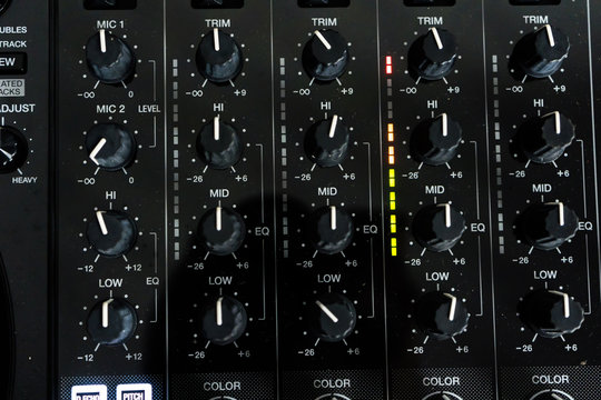 Wide angle photo of black sound mixer controller with knobs and sliders