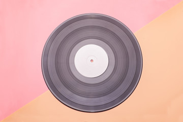 vinyl music disc with blank white label isolated on pink-brown background