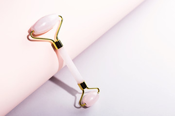 Creative shot of trendy pink jade roller.