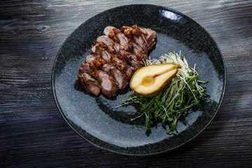 top view of grilled veal meat slices with half of baked pear