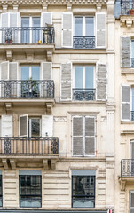 Multi-storey residential building with balconies and wooden shutters