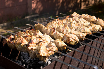 Kebab grilling on metal skewers. Grilled meat. Close up.