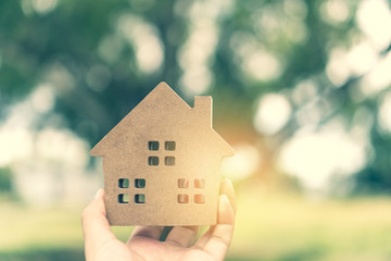 Copyspace model of a little house that woman holds it background.