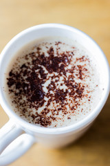 Coffee with foam and chocolate mug in a white mug. Cappuccino in a white mug. Good morning. Morning cappuccino for breakfast. Coffee in a mug top view. Macro shot of a coffee drink.