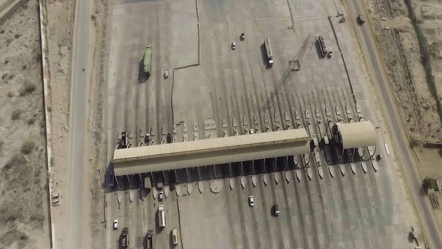Aerial view of a motorway toll plaza of the city, Heavy vehicles and others entering and crossing.