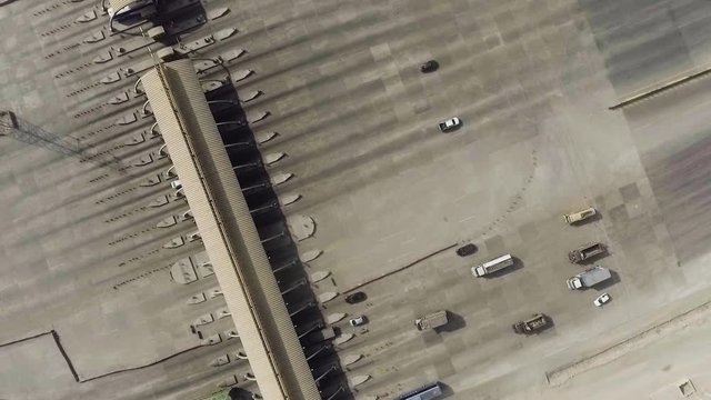 An aerial rotational view of a motorway toll plaza of the city, Heavy vehicles and others entering and crossing.