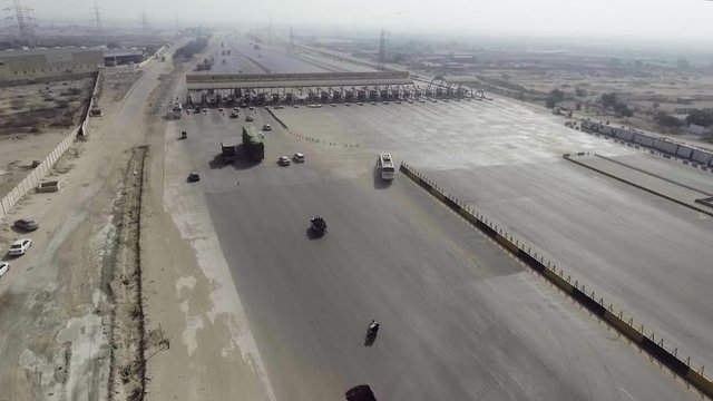 Aerial view of a motorway toll plaza of the city, Heavy vehicles and others entering and crossing.