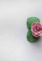 Pink rose on the right side of a white background. Background with beads. white background with roses.