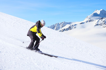Fototapeta na wymiar Alpine skier on piste running downhill