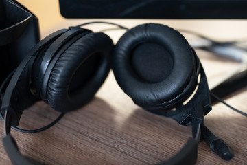 Fototapeta na wymiar black headphones with a microphone on a wooden table