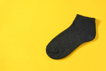top view of dark gray color men's socks  on yellow background with copy space, flat lay