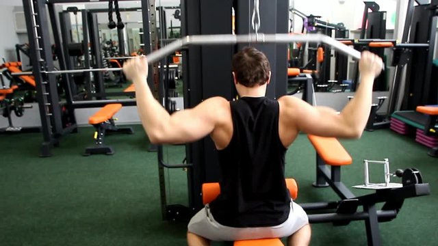 young athletic guy trains his back overall