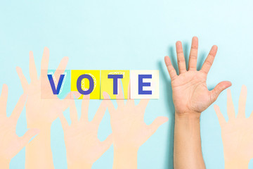 Vote word and opinion poll concept with hand palm raised on blue background