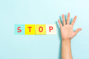 Stop sign concept with hand palm raised on blue background