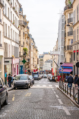 Street with shops and restaurants and residential buildings in Paris