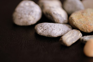 Fototapeta na wymiar Scattered pebble stones on a dark background close up