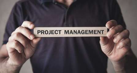 Man showing Project Management text on wooden block.